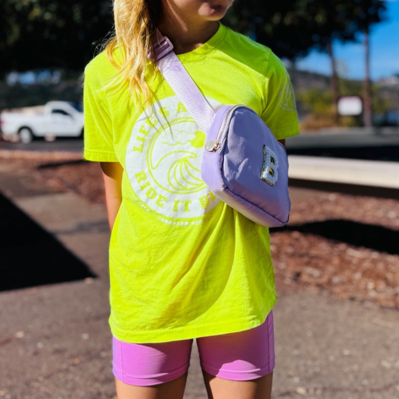 Girl wearing neon yellow life’s a wave coronado surf shirt